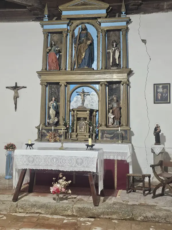 Vista completa del altar mayor con el retablo barroco policromado del siglo XVII