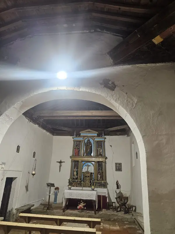 Vista completa de la nave con el arco de medio punto y el retablo al fondo