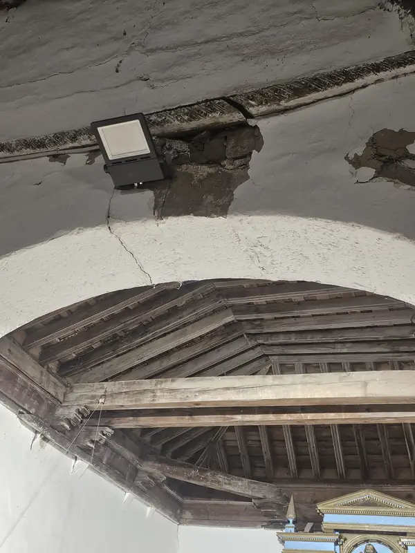 Daños estructurales en el techo de la iglesia, con piedra desprendida y grietas